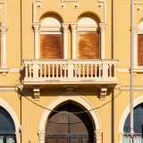 Il primo livello � invece contraddistinto da finestre ad arco (con sovrastanti decori a dentelli e a rosette), da un�elegante balconata centrale e da una merlatura sul parapetto